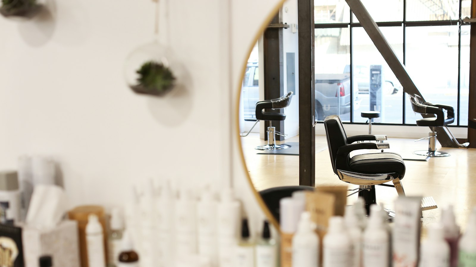 Hair salon station with a styling chair, mirror and shelves of hair care products